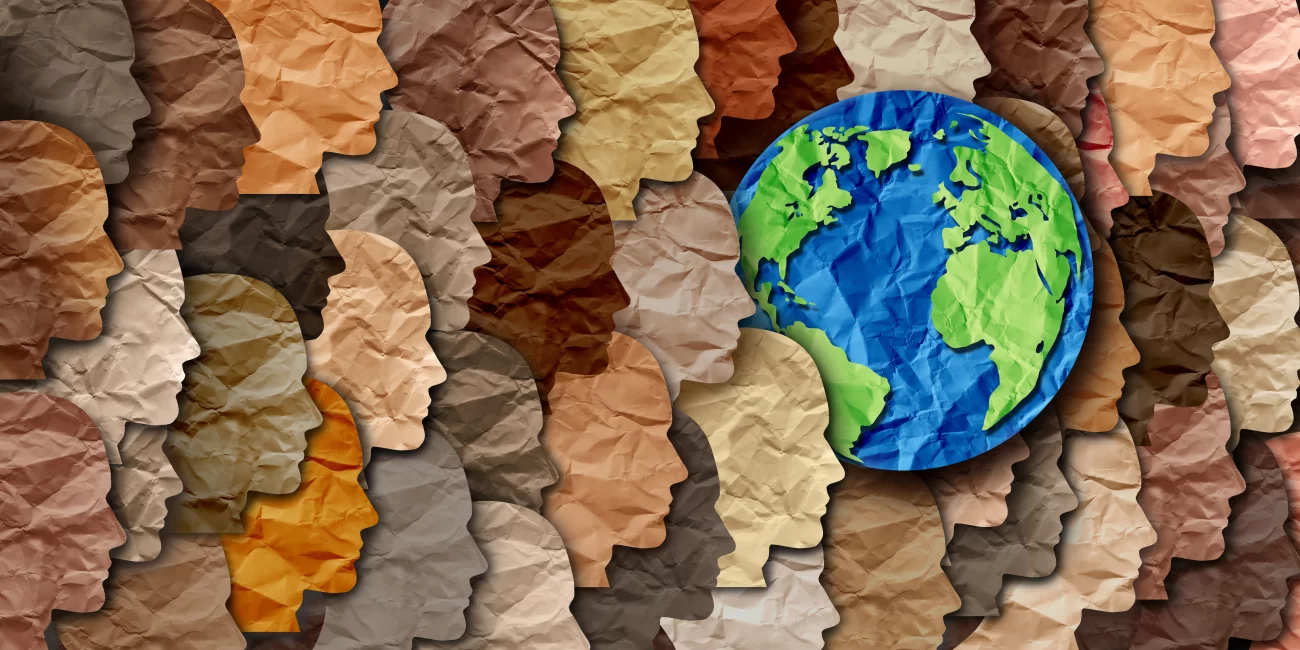 May Celebrations: Diversity, Education, and Awareness – this picture is of a series of paper side profile cut outs of heads in a range of skin tones, with a paper Earth in the middle.